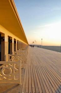 a boardwalk with chairs and a building on the beach at Superbe Studio Balcon Emplacement nº1: Place Morny in Deauville