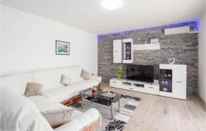 uma sala de estar com um sofá branco e uma televisão em Gorgeous Home In Dugopolje With Kitchen em Kapela