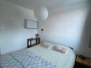 ein Schlafzimmer mit einem Bett mit einer weißen Bettdecke und einer Lampe in der Unterkunft Appartement Villard-de-Lans, 3 pièces, 6 personnes - FR-1-515-143 in Villard-de-Lans