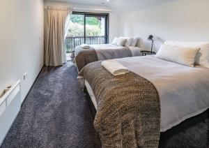 a bedroom with two beds and a window at Tranquil Stream Side Retreat in Wanaka