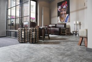 a lobby with furniture and a woman on the wall at Altstadt-Hotel Bielefeld in Bielefeld