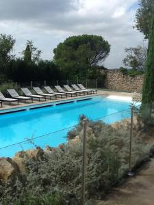 a swimming pool with chaise lounge chairs at Gordes Le Bastidon in Gordes