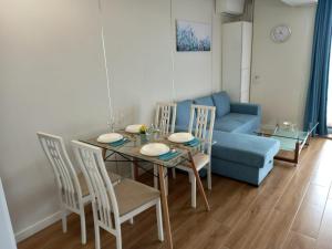 a living room with a table and a blue couch at Promenada Sea View with private parking in Mamaia Sat/Năvodari