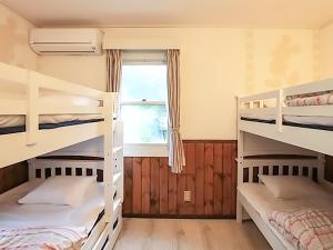 a bedroom with three bunk beds and a window at Human resort in Yamanakako