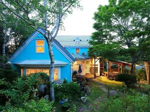 a blue house in a yard with trees at Human resort in Yamanakako