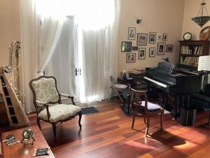 a living room with a piano and a chair at Lakeside Villa in Cottage Grove