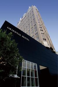 a tall building with a sign on the front of it at Oriental Hotel Hiroshima in Hiroshima