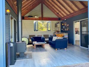 a living room with two blue chairs and a fireplace at Brett's Rest Nel in Kingscote