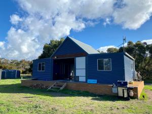 a blue tiny house sitting on top of a yard at Brett's Rest Nel in Kingscote