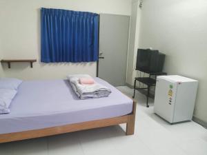 a bedroom with a bed and a television in it at Thanya Mansion in Kanchanaburi City