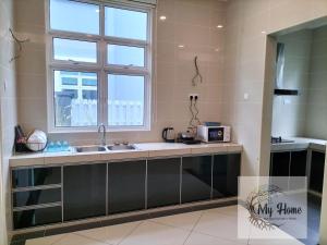 uma cozinha com um lavatório e uma janela em My Home Kayangan Villa Malacca C8 em Malaca