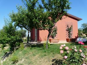 una casa rosa con rosas en el patio en L'Antigo Granaro, en Agugliano