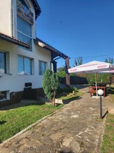 a table and an umbrella in front of a house at Guest House Plamena in Krapets