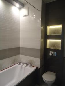 y baño con bañera blanca y aseo. en City Apartment, en Varsovia