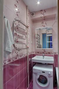 モスクワにあるCity Inn Apartments Savelovskayaのピンクのバスルーム(シンク、洗濯機付)