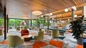 a lobby with colorful chairs and tables and windows at Eden Oak Geelong in Geelong