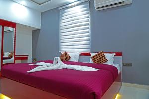 a bedroom with a purple bed with white sheets at M aples Jacks Place in Cavelossim
