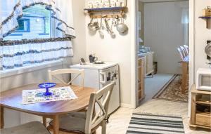 ein Esszimmer mit einem Tisch und einer Küche in der Unterkunft Cozy Home In Repvg With House A Panoramic View in Repvåg