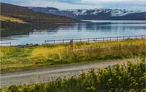 una strada sterrata vicino a un corpo d'acqua. di Cozy Home In Repvg With House A Panoramic View a Repvåg