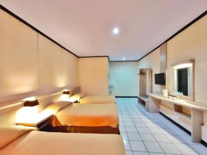 Habitación de hotel con 2 camas y lavamanos en Bromo Permai 1 en Bromo
