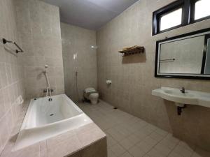 ein Badezimmer mit Badewanne, Toilette und Waschbecken in der Unterkunft Bromo Permai 1 in Bromo