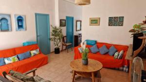 ein Wohnzimmer mit zwei orangenen Sofas und einem Tisch in der Unterkunft House with exclusive pool and garden 7 min walk from the beach and the center in El Campello