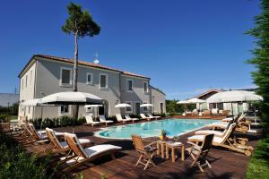 a pool with chairs and tables and a building at San Giovanni Relais in San Giovanni in Marignano