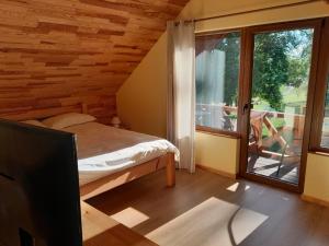 um quarto com uma cama e uma grande janela em Guest house Vilciņi em Bernāti
