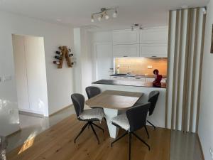 a dining room with a table and chairs and a kitchen at Delux apartment ARSO in Velenje