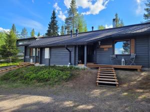 une maison avec une terrasse couverte et des escaliers. dans l'établissement Vuosselin Tähti, à Ruka