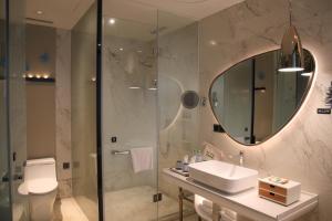 a bathroom with a sink and a shower and a mirror at Wingate by Wyndham Sanya Luhuitou in Sanya