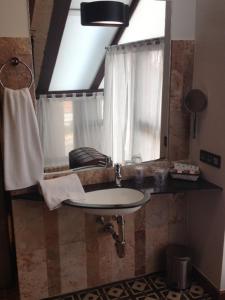 a bathroom with a sink and a window at Hotel Rural Doña Berenguela in Bolaños de Calatrava