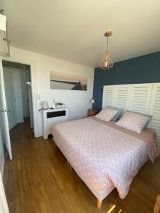 1 dormitorio con 1 cama grande y pared azul en La Villa plein vent "Lumière du Cap" vue mer en Barneville-Carteret