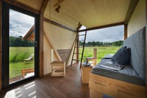a room with a bed and a ladder and a window at Glamping Hluboká in Hluboká nad Vltavou