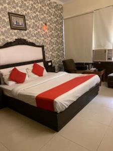 a bedroom with a large bed with red pillows at Hotel City Paradise in Chandīgarh