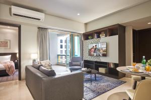 Somerset Bencoolen Singapore في سنغافورة: غرفة معيشة مع أريكة وغرفة طعام