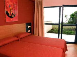 a bedroom with a bed and a large window at Hotel Parrilla el Zangano in Boal