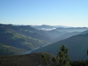 a view of a valley from a mountain with a lake at Hotel Parrilla el Zangano in Boal