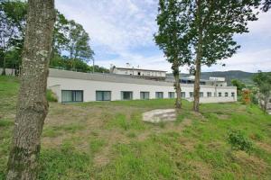 a large white building with trees in front of it at Hotel Parrilla el Zangano in Boal