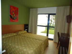 a bedroom with a bed and a large window at Hotel Parrilla el Zangano in Boal