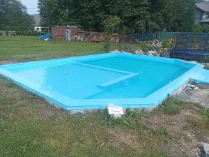 una gran piscina azul en un patio en Chata Tánička, en Jeseník