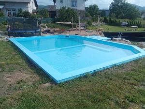 a large blue swimming pool in the grass at Chata Tánička in Jeseník