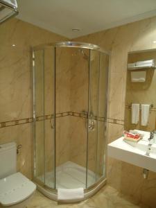 Un baño con ducha, inodoro y lavabo. en Hotel Parrilla el Zangano, en Boal