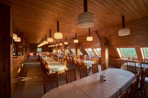 a dining room with tables and chairs and lights at Apartmán 206 Žalý in Benecko