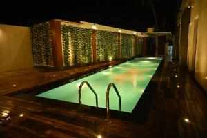a swimming pool at night with two handles in it at Kalki Hotel in Port Blair