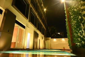 a building with a swimming pool at night at Kalki Hotel in Port Blair