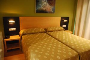 a bedroom with a bed and two night stands at Hotel Parrilla el Zangano in Boal