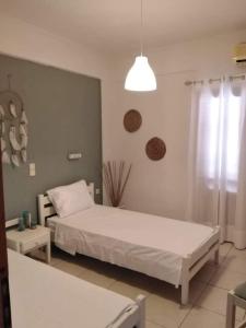 een slaapkamer met een wit bed en een raam bij Cozy Apartments in Istron