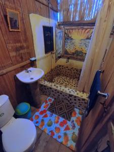 y baño con aseo y lavamanos. en Hostal Camping Sin Fronteras Mompiche, en Mompiche