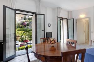 uma sala de jantar com uma mesa e uma varanda em 13 Mehari em Varigotti